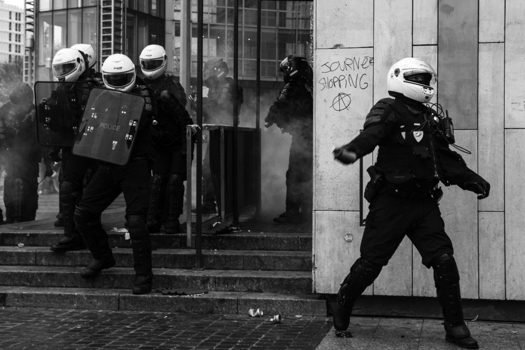 A police officer throws a tear gas canister at demonstrators. A few thousand people took to the streets to celebrate the first anniversary of the yellow vest movement, Paris on 16 November 2019. Un policier jete une grenade lacrymogène sur des manifestants. Quelques milliers de personnes sont sorties dans les rues pour fêter les 1 an du mouvement des gilets jaunes,  Paris le 16 novembre 2019.